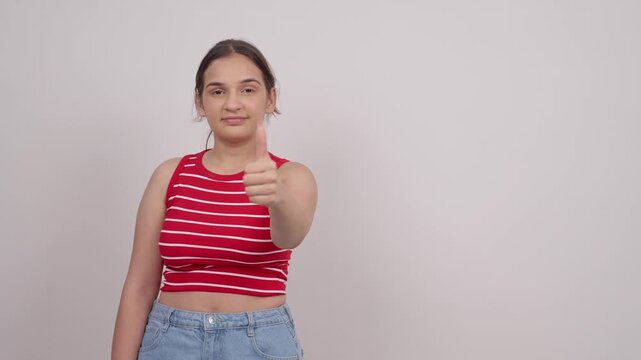 Indian Teenage Girl Pointing at Copy Space and Showing Thumbs Up
