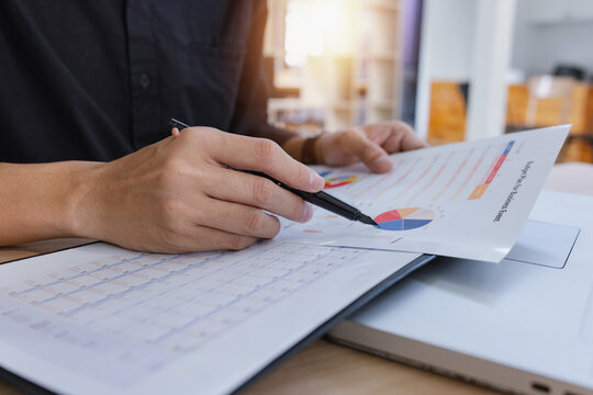 A businessman analyzing financial reports charts and data graphs in an office environment focusing on business growth and strategy.