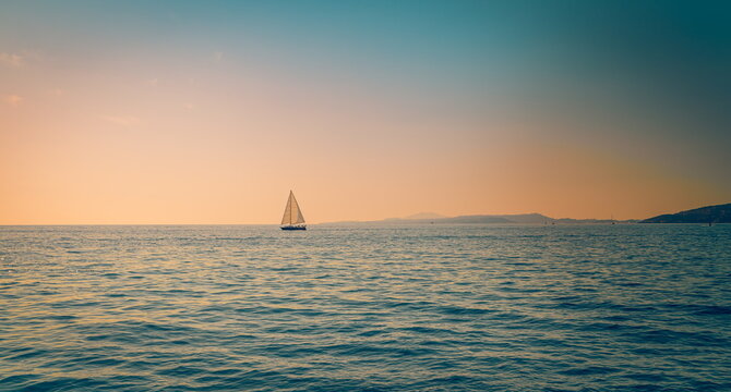 Serene white sailboat golden sunset calm sea glowing horizon summer evening voyage peaceful ocean water. Peaceful summer nature seascape meditation. Relaxing sailing inspiring coastal wellbeing scene