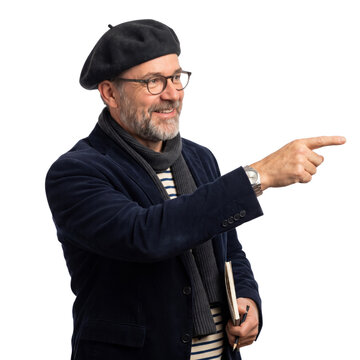 Smiling mature man in a beret and glasses holding a notebook and pointing his finger isolated on transparent background.