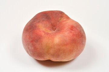 A whole ripe flat peach also known as saturn peach isolated on a clean white surface © nahhan
