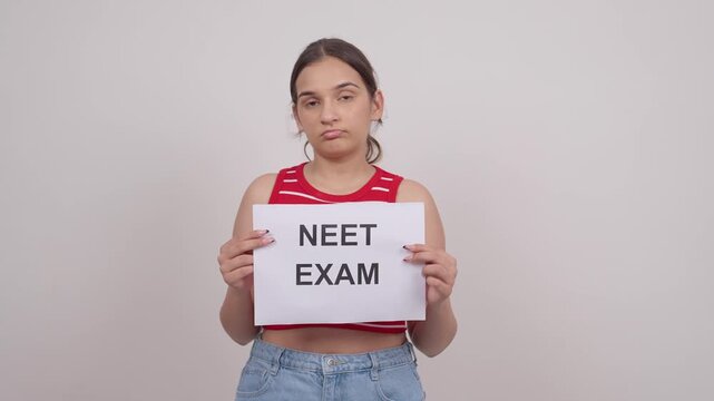 Sad Indian Teenage Girl Holding NEET EXAM Poster