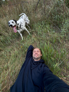 Man And Dalmatian Dog Taking Selfie Outdoors in Field