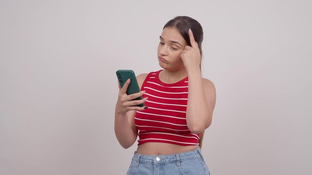Indian Teenage Girl Looking at Phone and thinking