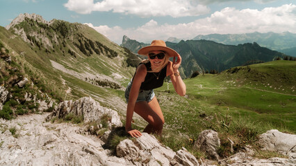 Smiling Female Hiker Climbing Rocky Trail with Alpine Mountain Landscape © The Nomad Nextdoor