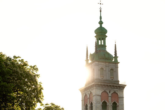 Historic tower spire bathed in bright sunlight with lens flare effect