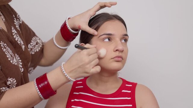 Makeup Artist Using Makeup Brush on Indian Teenage Girl 