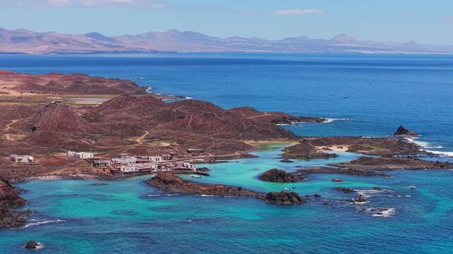 Areal views of Lobos Island, a small, uninhabited volcanic nature reserve with crescent-shaped white sand beach with crystal-clear turquoise waters located in Fuerteventura, Canary Islands, Spain.