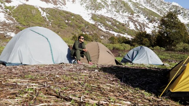 Mountain Camping With Tents and Traveler Surrounded by Snowy Himalayan Peaks