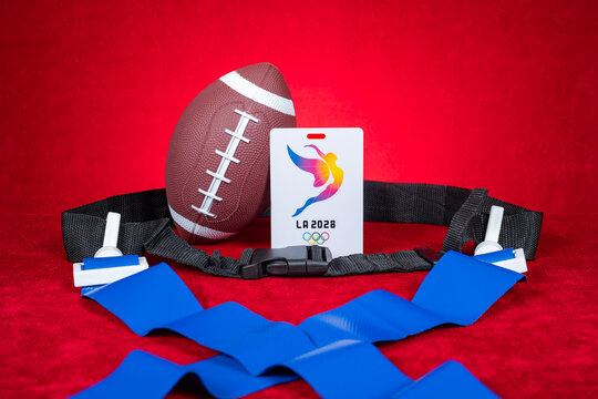 ZhongShan GuangDong China-August 27, 2026: American flag football gear with LA2028 Los Angeles Olympic Games accreditation badge against red velvet backdrop.