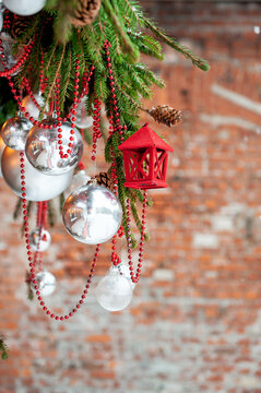 Rustic brick backdrop with christmas ornaments hang from spruce branches