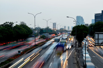 Background of busy city traffic with the dynamic motion of car light trails on the road in the late afternoon. © Yudy Pirmansah