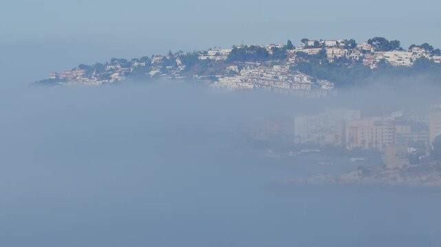 Time-lapse video of a dramatic morning fog and low clouds moving from the calm Mediterranean sea towards the beach in Almunecar, Spain in the early morning.