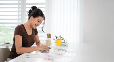 Woman at home spends time on hobby Stringing beads.Home studio creativity and art concept. © Fahng