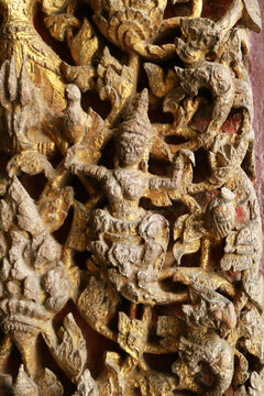 Close-up of ancient Ayutthaya style wood carving depicting deity and mythical creatures on temple door at Wat Na Phra Meru, Ayutthaya, Thailand