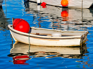 Small Fishing Boats with Bright Red Buoys Reflected in Calm Harbour Waters © susie peek