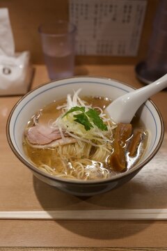 澄んだ透明スープに繊細なトッピングが映える上品な淡麗系塩ラーメン  
Refined clear broth shio ramen topped with sliced pork, green scallions, and bamboo shoots
