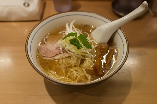 澄んだ透明スープに繊細なトッピングが映える上品な淡麗系塩ラーメン  
Refined clear broth shio ramen topped with sliced pork, green scallions, and bamboo shoots
