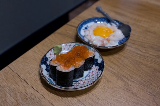 イクラ軍艦と卵黄を添えた海鮮小鉢が並ぶ和食の美しい小皿料理  
Beautiful Japanese small plates featuring ikura gunkan sushi and seafood with egg yolk
