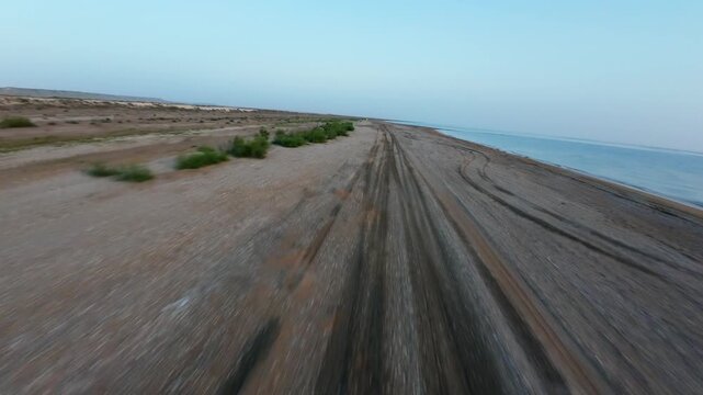 Fast forward tracking shot along coastal dirt track