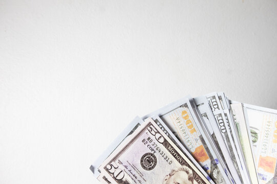Fan of US dollar bills in the bottom right corner on a white background with large copy space. Concept of wealth, salary, business investment, budget planning, and financial success.