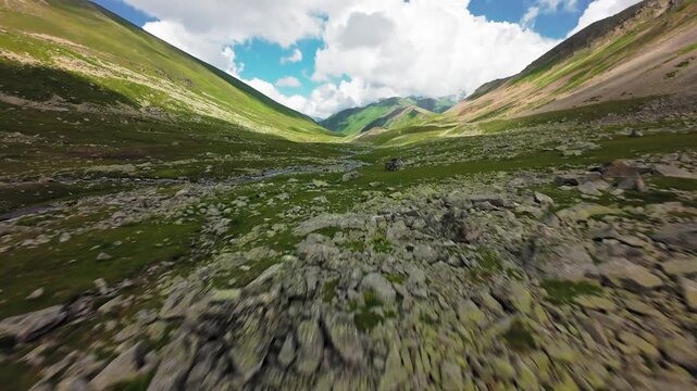 Fast forward aerial flight over mountain valley stream