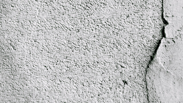 Black and white textured concrete wall with crack details along the edges.