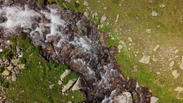 Aerial view of a rushing mountain stream flowing over rocks