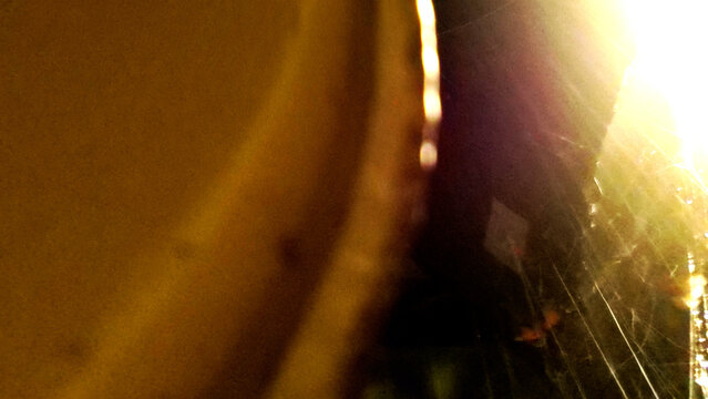 Abstract golden lens flare effect with warm light leak bokeh and scratched film texture overlay for creative cinematic video transition design