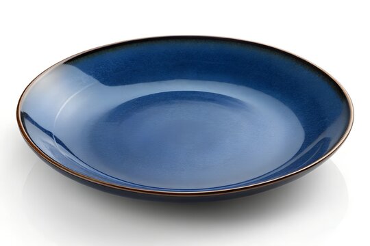 Empty deep blue ceramic dinner plate with rustic rim on a white surface