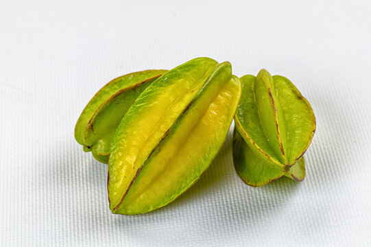 Fresh star fruit on white textured surface
