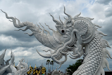Fototapeta premium Intricate white dragon sculpture against a cloudy sky