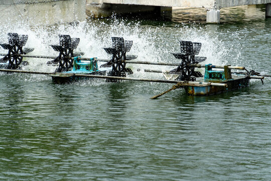 Water aeration turbines spinning vigorously in a pond creating splashes