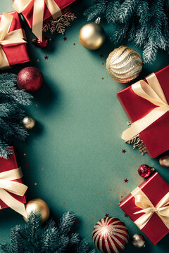 Red Christmas gifts and ornaments vertical frame on green background