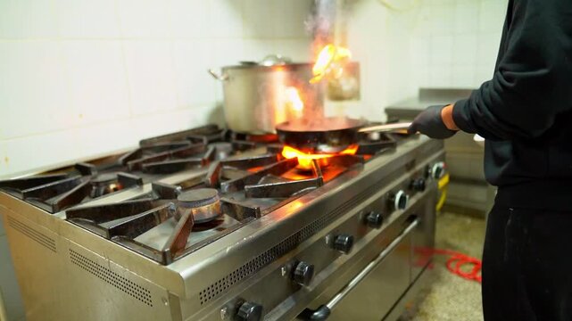 Professional chef flambeing food in a pan