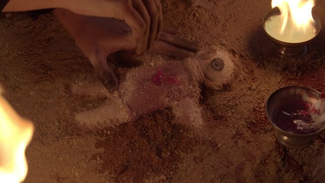 A woman removes a needle from a voodoo doll and this starts to bleed.
