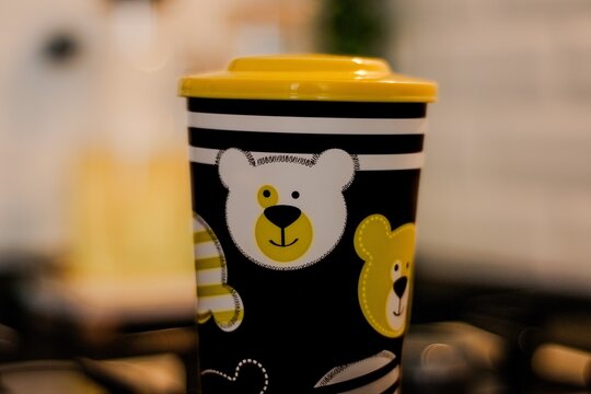 Reusable black and yellow plastic tumbler cup with cute bear illustration