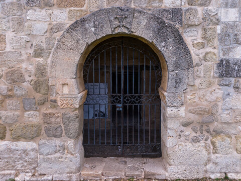 Close-up shot of horseshoe arch portal and carved cross at the Visigothic Basilica of San Juan de Banos.