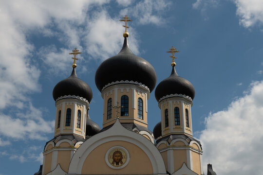 a monastery with three domes against a blue sky