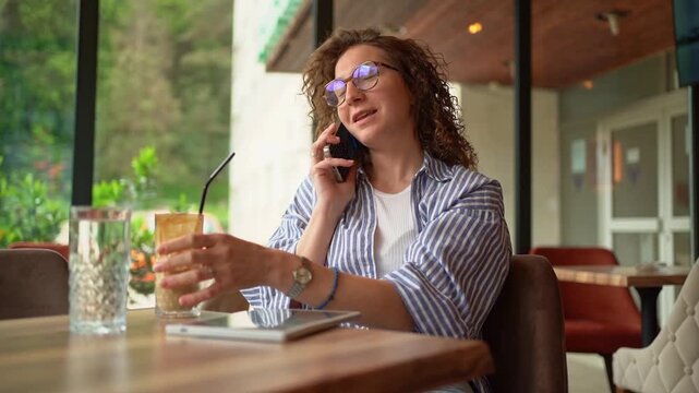 Candid woman talking on phone in a coffee shop