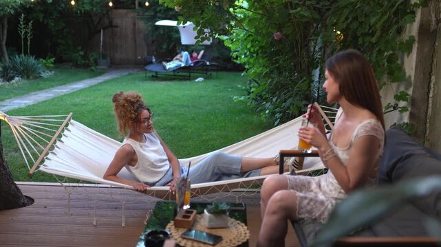 Two young women enjoying cocktails in a garden cafe