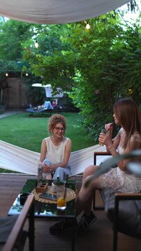 Young women enjoying a conversation at relaxing garden party
