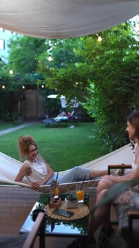 Two young women enjoying a conversation in a garden cafe