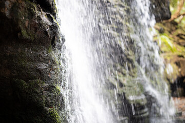 Cascading Waterfall Amidst Mossy Rock Formation © LightItUp