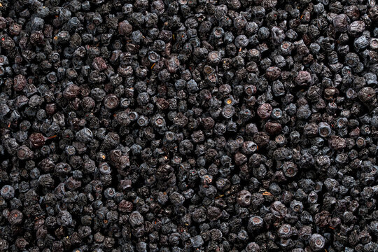 Full frame texture of dried organic blueberries background. Top view closeup of large pile of dark dried blueberries creating detailed natural berry texture pattern