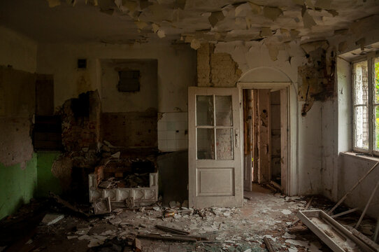 Abandoned overgrown mansion with spiral staircase, old car and ruined interior