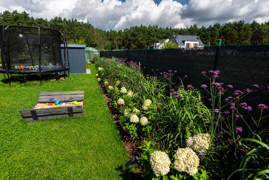 Suburban backyard garden with play area and fence