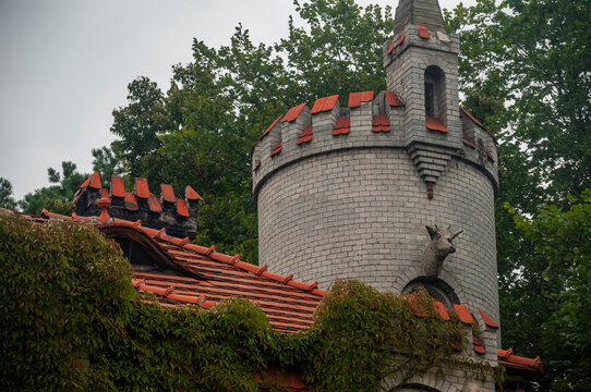 Abandoned overgrown mansion with spiral staircase, old car and ruined interior