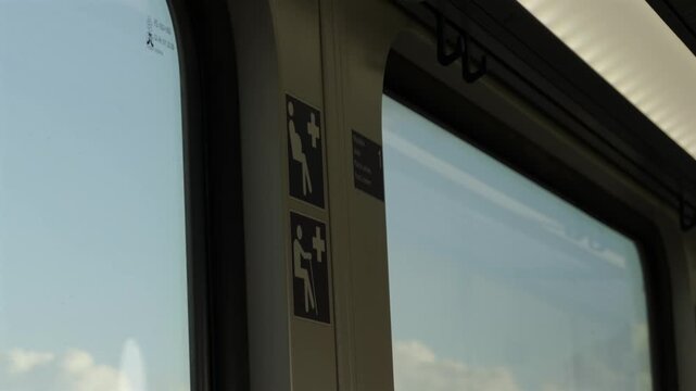 Close up shot of passenger train information icons marking designated courtesy seats for elderly disabled or pregnant commuters inside a modern railway car. Inside a moving regional train