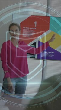Animation of cyber security text, sheild icon over caucasian woman giving a presentation at office